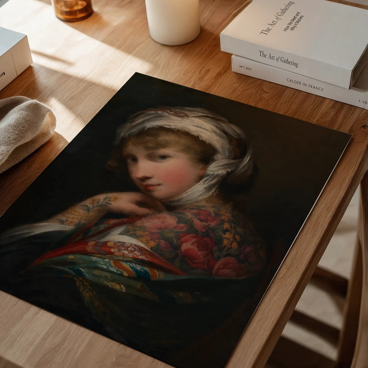 The print of a headscarfed lady portrait hanging in a dining room