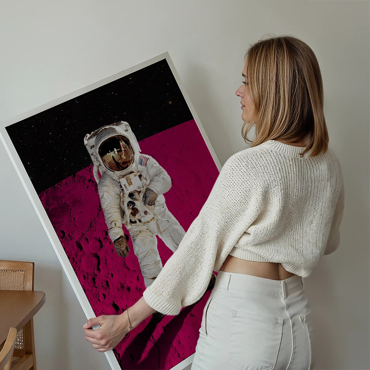 Astronaut pink moon print displayed on a living room wall as a bold space-themed focal point