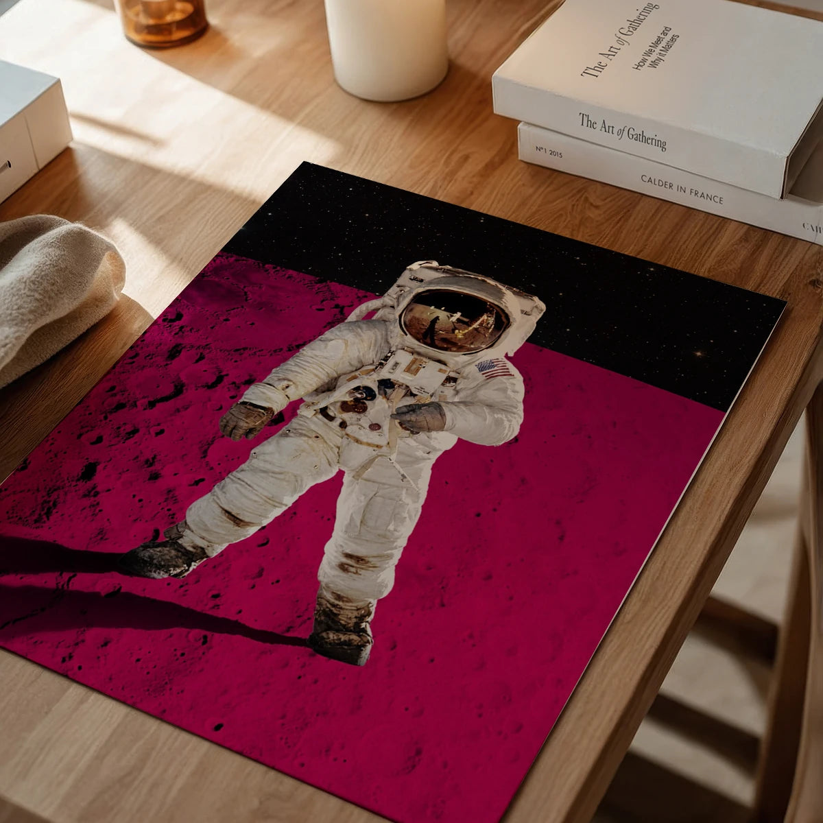 The print of a spacesuited astronaut on a pink lunar surface in a dining room setting