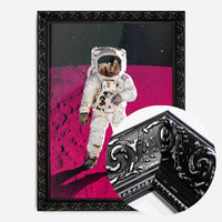 astronaut on pink moon print in a black ornate frame, side profile