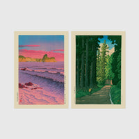 Set of 2 framed prints, Kawase Hasui Japanese woodblock prints: a pink sunset over ocean waves and cliffs; and a cedar forest path with a lone walker — unframed