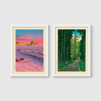 Set of 2 framed prints, Kawase Hasui Japanese woodblock prints: a pink sunset over ocean waves and cliffs; and a cedar forest path with a lone walker — unframed
