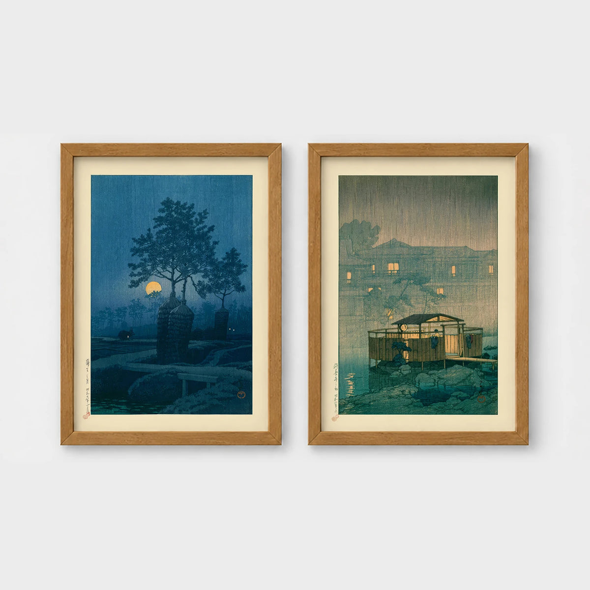 Set of 2 framed prints, Kawase Hasui Japanese woodblock prints (night scenes): a moonlit tree and stone lantern at night; and a misty rain-soaked house with lantern light at dusk — unframed