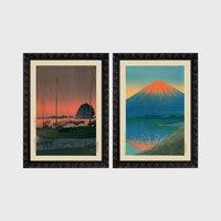 Set of 2 framed prints, Kawase Hasui Japanese woodblock prints: sailboats moored at a harbour at dusk; and Mount Fuji glowing red at sunset, reflected in the water — unframed
