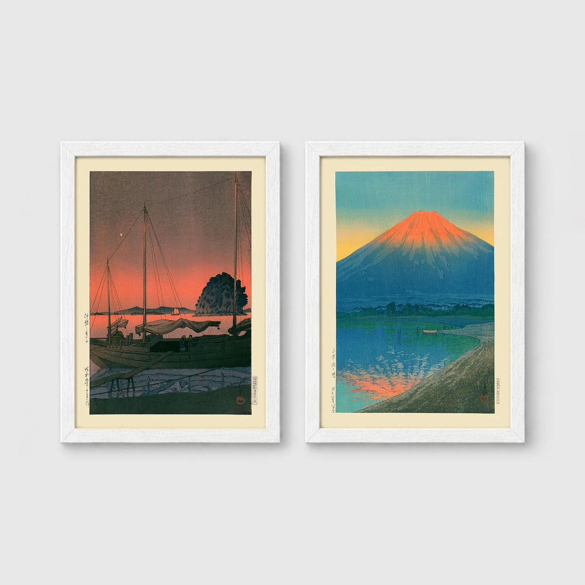 Set of 2 framed prints, Kawase Hasui Japanese woodblock prints: sailboats moored at a harbour at dusk; and Mount Fuji glowing red at sunset, reflected in the water — unframed