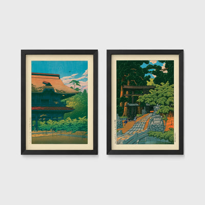 Set of 2 framed prints, Kawase Hasui Japanese woodblock prints: a temple building with a red roof against a blue sky; and a temple approach path with figures beneath trees — unframed