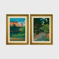 Set of 2 framed prints, Kawase Hasui Japanese woodblock prints: a temple building with a red roof against a blue sky; and a temple approach path with figures beneath trees — unframed