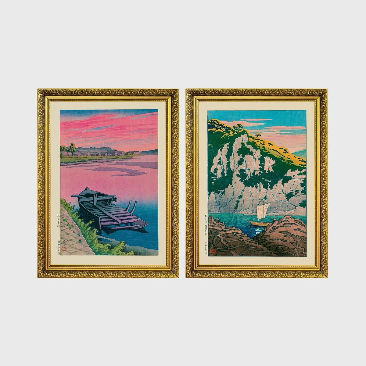 Set of 2 framed prints, Kawase Hasui Japanese woodblock prints: a pink sunset lake scene with a moored boat; and green coastal cliffs with a small sailboat — unframed