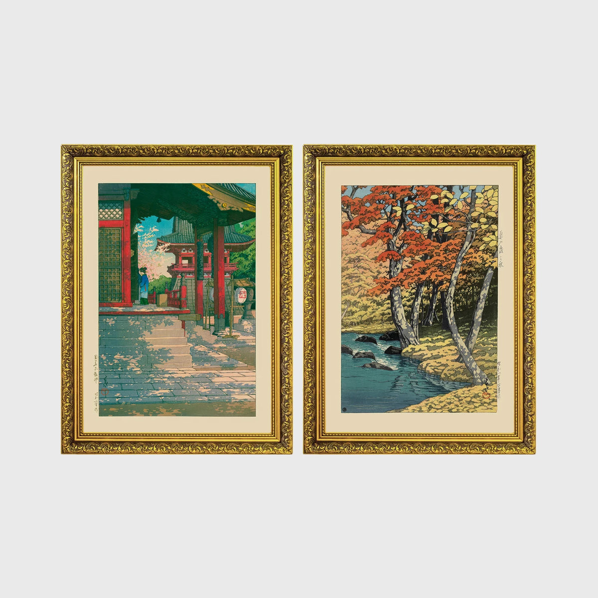 Set of 2 framed prints, Kawase Hasui Japanese woodblock prints: a red temple gate and pavilion with a figure; and a stream through autumn foliage — unframed