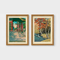 Set of 2 framed prints, Kawase Hasui Japanese woodblock prints: a red temple gate and pavilion with a figure; and a stream through autumn foliage — unframed