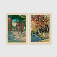 Set of 2 framed prints, Kawase Hasui Japanese woodblock prints: a red temple gate and pavilion with a figure; and a stream through autumn foliage — unframed
