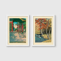 Set of 2 framed prints, Kawase Hasui Japanese woodblock prints: a red temple gate and pavilion with a figure; and a stream through autumn foliage — unframed
