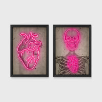 Set of 2 framed prints, neon anatomical illustrations: a neon pink anatomical heart illustration; and a neon pink skeleton skull and ribcage illustration — unframed