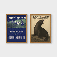 Set of 2 framed prints, vintage Northumberland travel posters: a "The Lure of Northumberland" poster of riders at night; and a "Holy Island Northumberland" poster featuring a seal — unframed