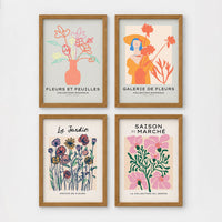 Set of 4 framed prints, pop art and vintage-poster mix: a Warhol-style pop art skull in orange on blue; an "L'atelier des Fleurs" floral botanical poster; a "Welcome To The Freak Show" vintage floral circus poster; and a still life with a skull and jar, overlaid with colourful polka dots — unframed
