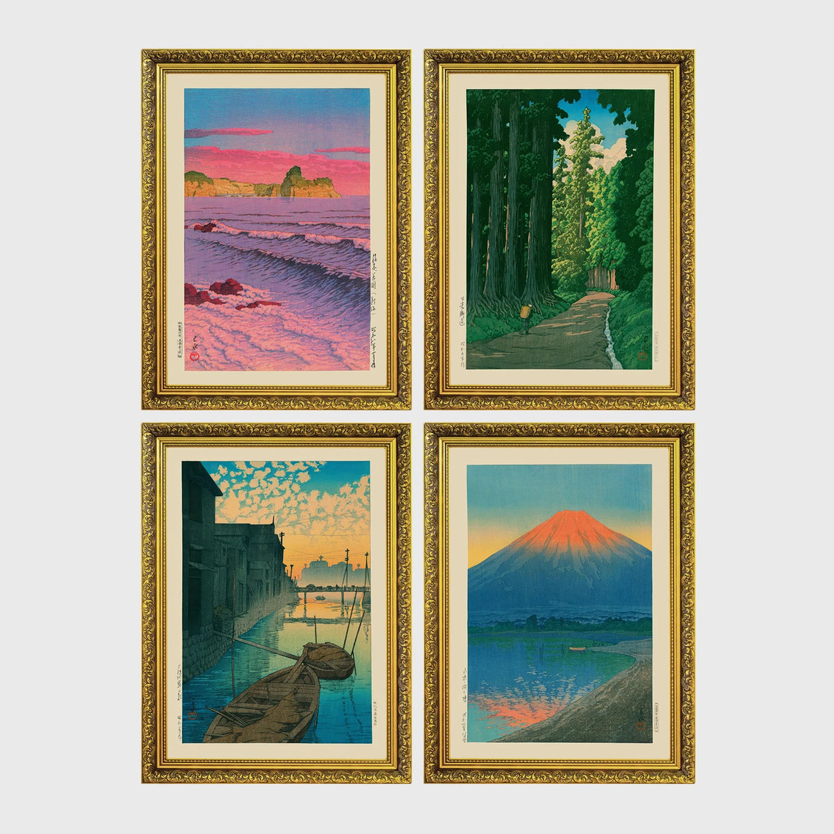 Set of 4 framed prints, Kawase Hasui Japanese woodblock prints: pink sunset over ocean waves and cliffs; a cedar forest path with a lone walker; boats moored on a canal at dawn beneath a cloud-streaked sky; and Mount Fuji glowing red at sunset, reflected in the water — unframed