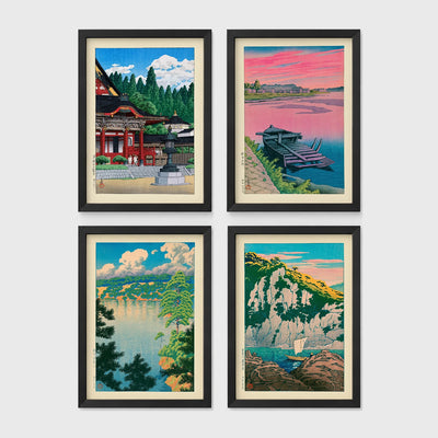 Set of 4 framed prints, Kawase Hasui Japanese woodblock prints: a red shrine framed by pine trees under a blue sky; a pink sunset over a lake with a moored boat; a lake view framed by pine branches beneath drifting clouds; and green coastal cliffs with a waterfall over turquoise water — unframed