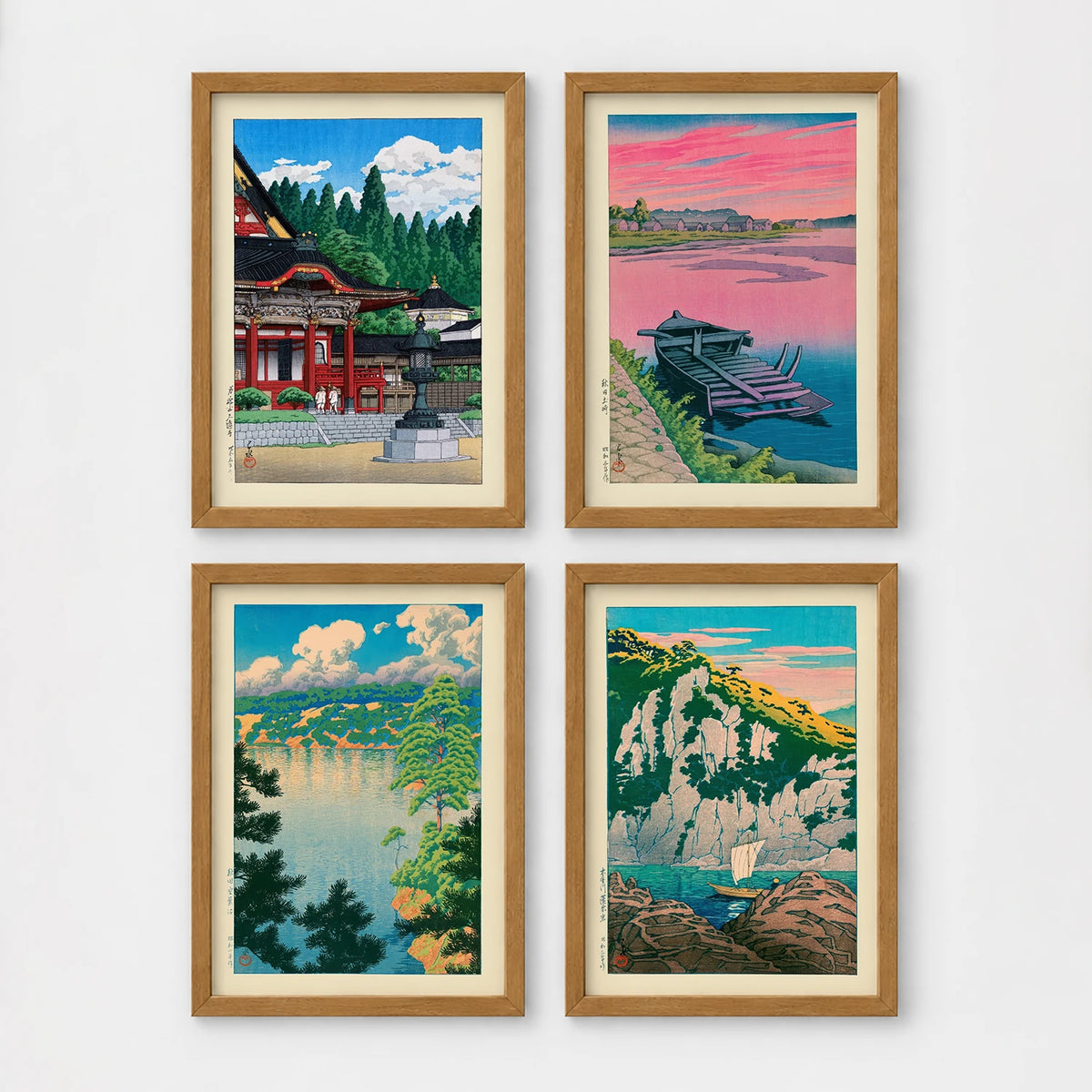 Set of 4 framed prints, Kawase Hasui Japanese woodblock prints: a red shrine framed by pine trees under a blue sky; a pink sunset over a lake with a moored boat; a lake view framed by pine branches beneath drifting clouds; and green coastal cliffs with a waterfall over turquoise water — unframed