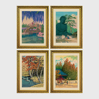 Set of 4 framed prints, Kawase Hasui Japanese woodblock prints (landmarks): a red arched bridge beneath cascading wisteria and cherry blossom; the Great Buddha of Kamakura among pine trees; a stream through autumn foliage; and a red pagoda gate in an autumn forest — unframed