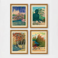 Set of 4 framed prints, Kawase Hasui Japanese woodblock prints (landmarks): a red arched bridge beneath cascading wisteria and cherry blossom; the Great Buddha of Kamakura among pine trees; a stream through autumn foliage; and a red pagoda gate in an autumn forest — unframed