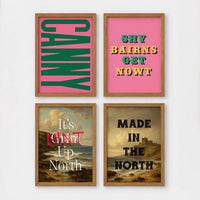 Set of 4 framed prints, Newcastle & Geordie dialect prints: the word "Canny" in bold green retro type on pink; the Geordie slogan "Shy Bairns Get Nowt" in bold retro type on pink; "It's Mint Up North" over a coastal landscape; and "Made in the North" over a coastal castle landscape — unframed