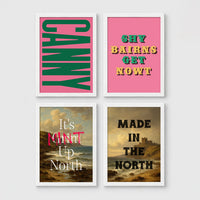 Set of 4 framed prints, Newcastle & Geordie dialect prints: the word "Canny" in bold green retro type on pink; the Geordie slogan "Shy Bairns Get Nowt" in bold retro type on pink; "It's Mint Up North" over a coastal landscape; and "Made in the North" over a coastal castle landscape — unframed