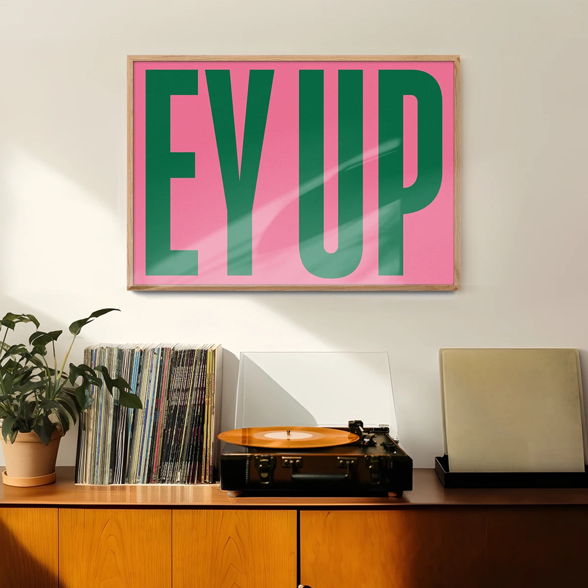 Bold pink and green typography wall art hung in a hallway