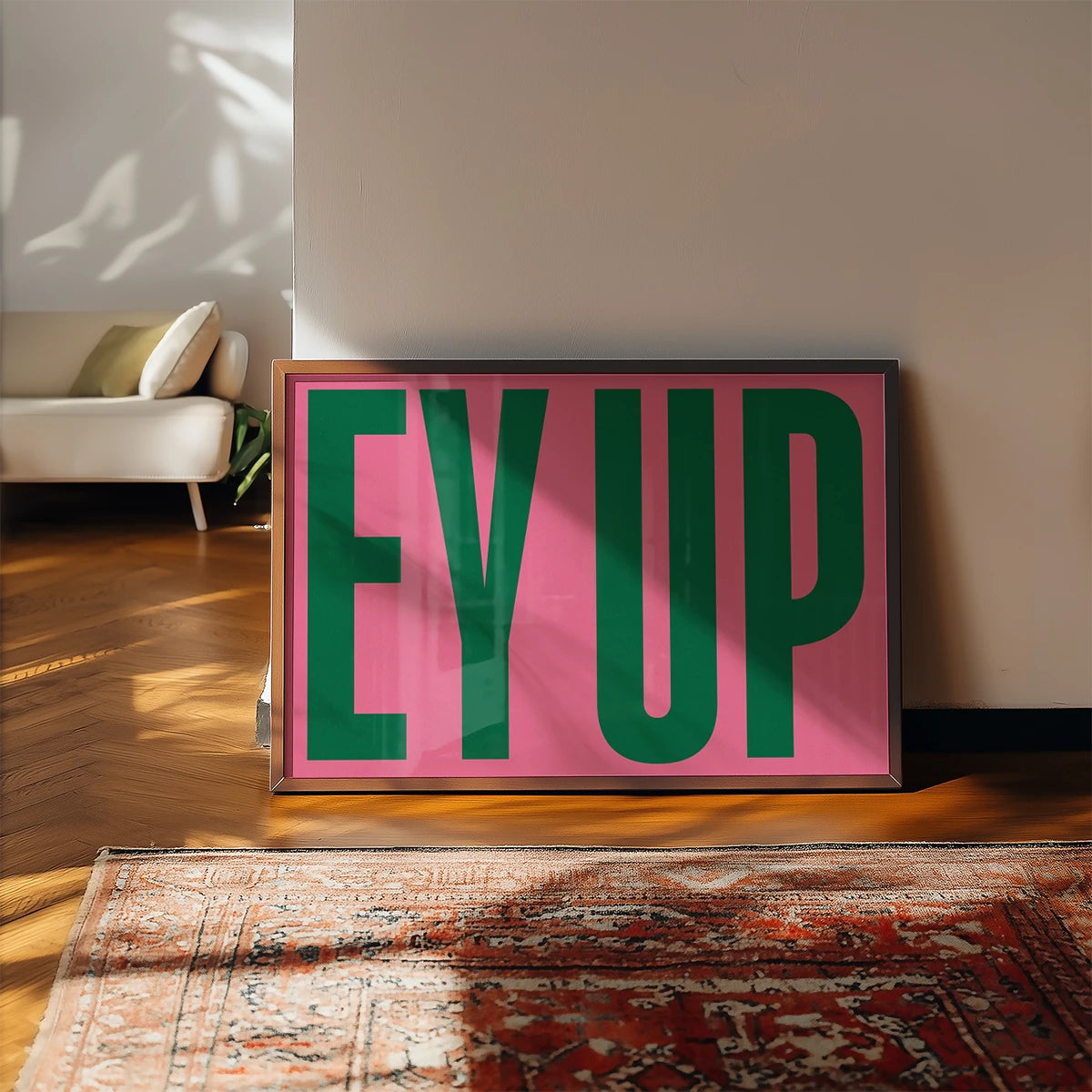 Bold typography print in green and pink displayed in a kitchen