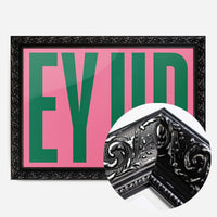 bold pink green typography print in a black ornate frame, side profile
