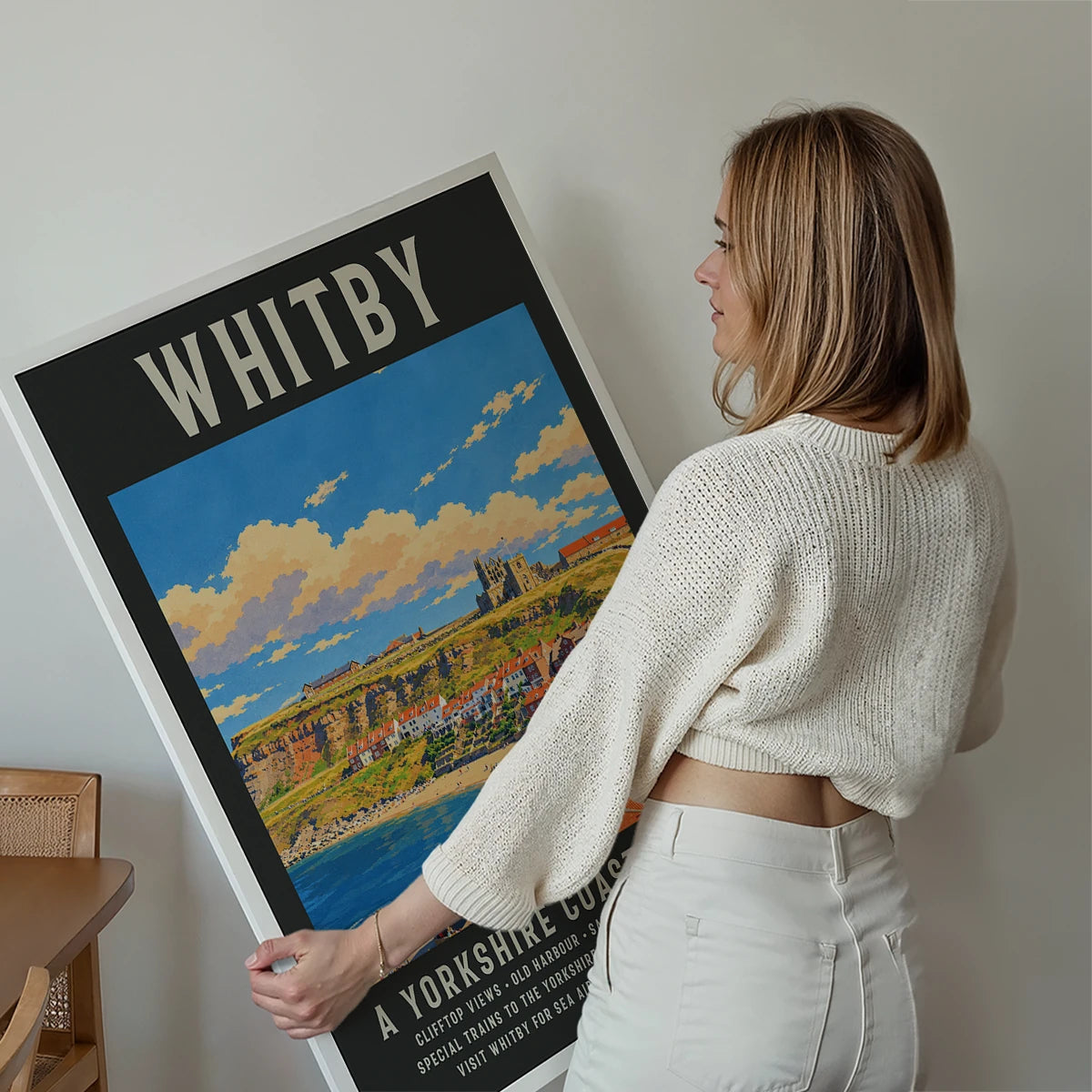 Whitby travel poster print displayed on a living room wall, showing the abbey and harbour