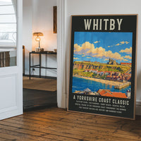 Whitby harbour poster art hanging in a hallway, with red-roofed cottages and blue sea