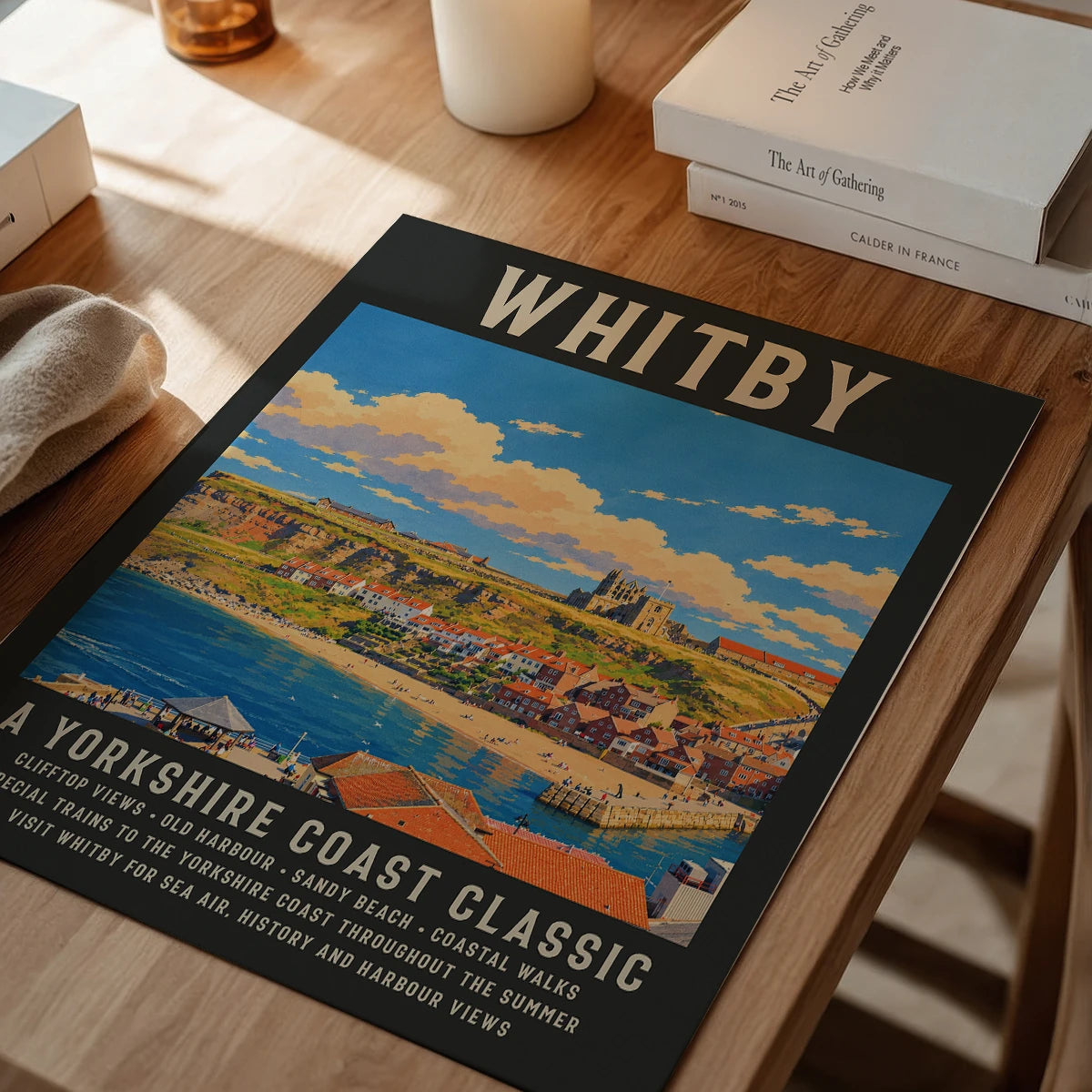 Framed Whitby coastal poster on a dining room wall, showing the old harbour and cliffs