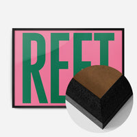 bold green reet typography print in a black wood frame, side profile