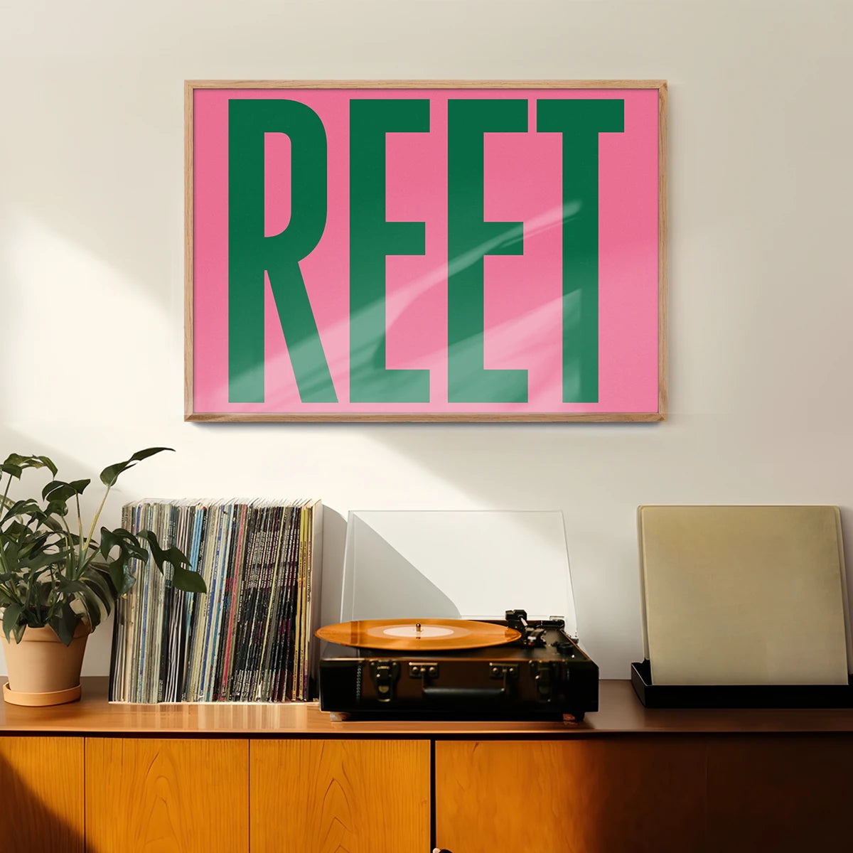 Bold green and pink typography poster displayed in a hallway