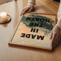 The print showing bold lettering over a vintage hillside castle, in a bedroom setting