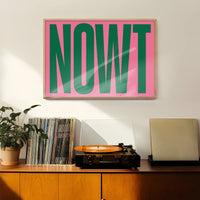 Bold green and pink typography print hanging in a hallway