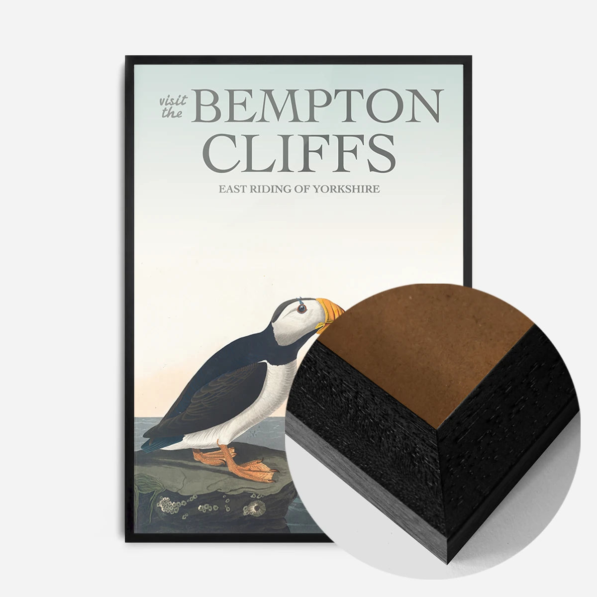 vintage puffins on coastal rock print in a black wood frame, side profile