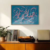 Ornate calligraphy lettering print on teal hung in a welcoming hallway