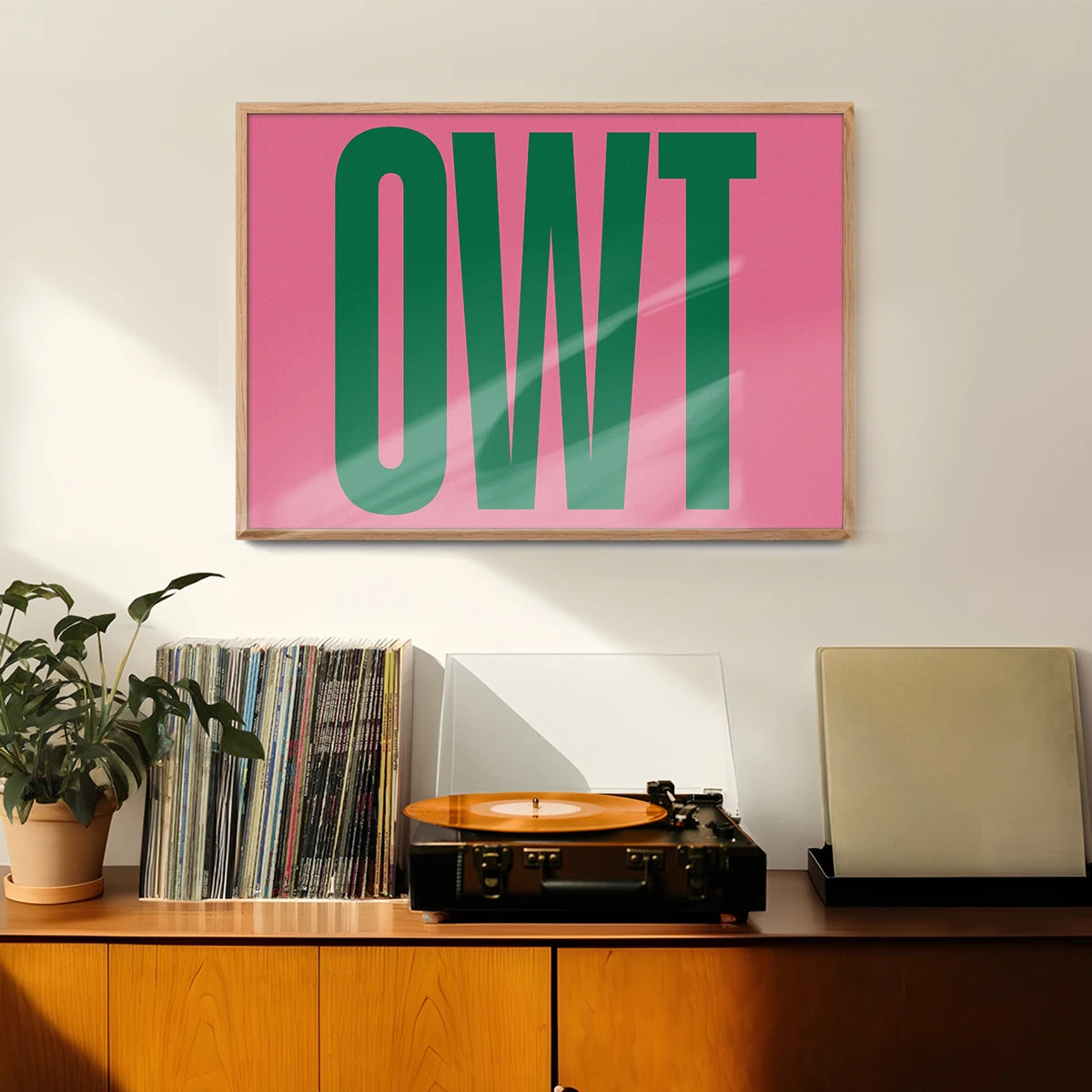 Bold green and pink typography print on the wall of a welcoming hallway