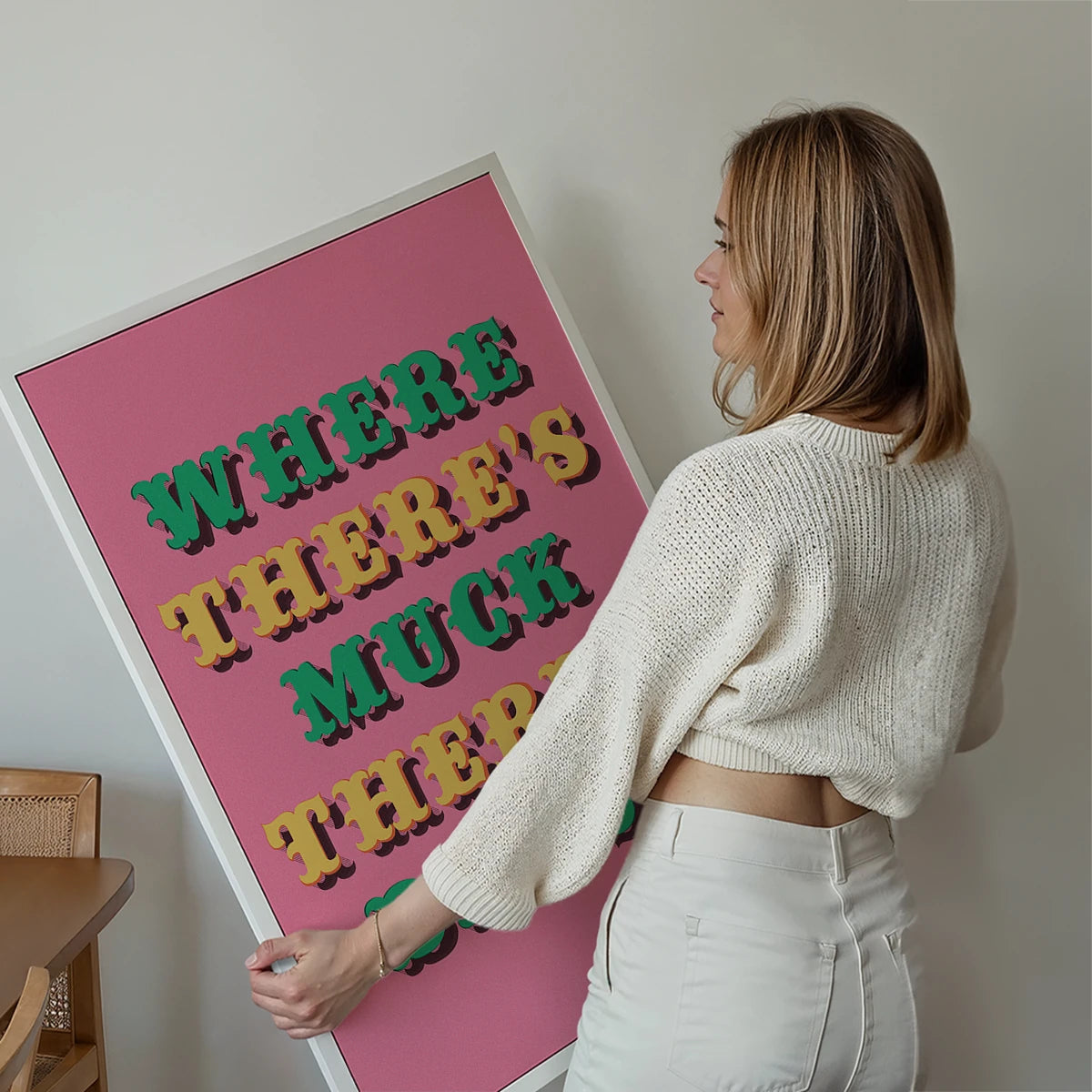 Where There's Muck There's Brass print framed on a living room wall, bold pink northern saying typography